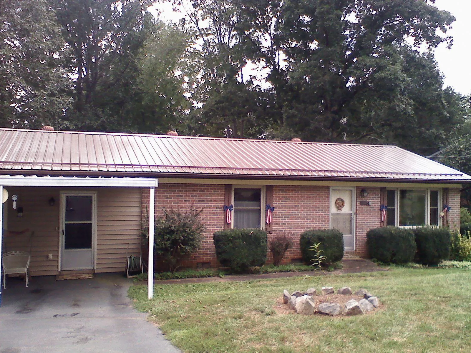 Bronze metal roof and carport on a brick ranch home — Roof Repair work by our crew in Mc Leod