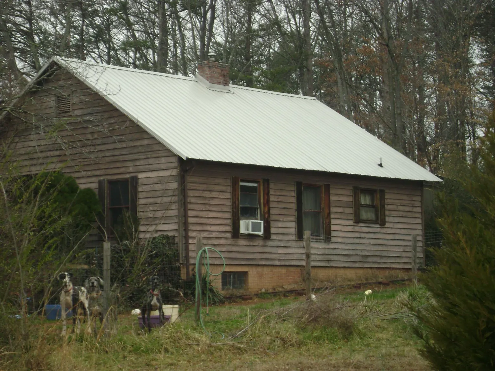 White metal roof on an old wood sided farmhouse, from a Metal Roof Installation job in Mc Leod